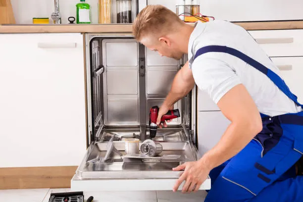 Professional plumber fixing a kitchen sink in JLT